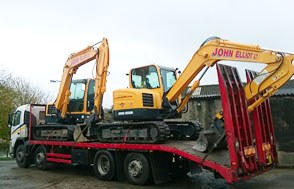 Beavertail wagon carrying two yellow excavators