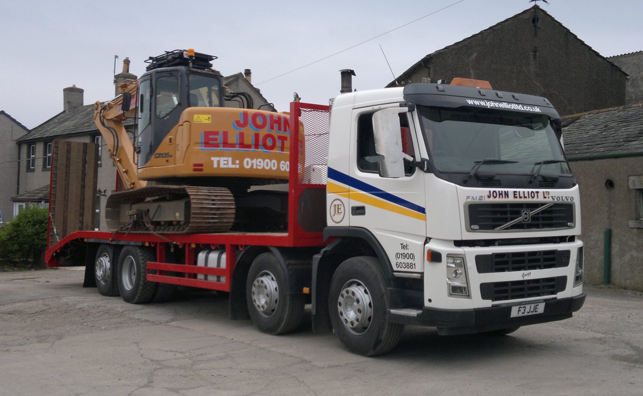 White John Elliot Ltd beavertail wagon carrying a tracked excavator in the farm yard at Great Clifton